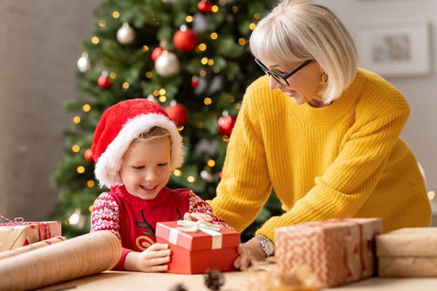 excited kid santa hat opening gift box granny while celebrating excited kid santa hat opening gift box granny while celebrating