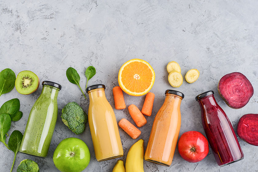 green yellow orange and red smoothie in glass bottles