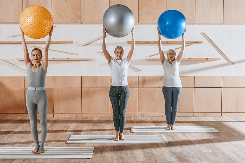 group senior people exercising fitness balls studio