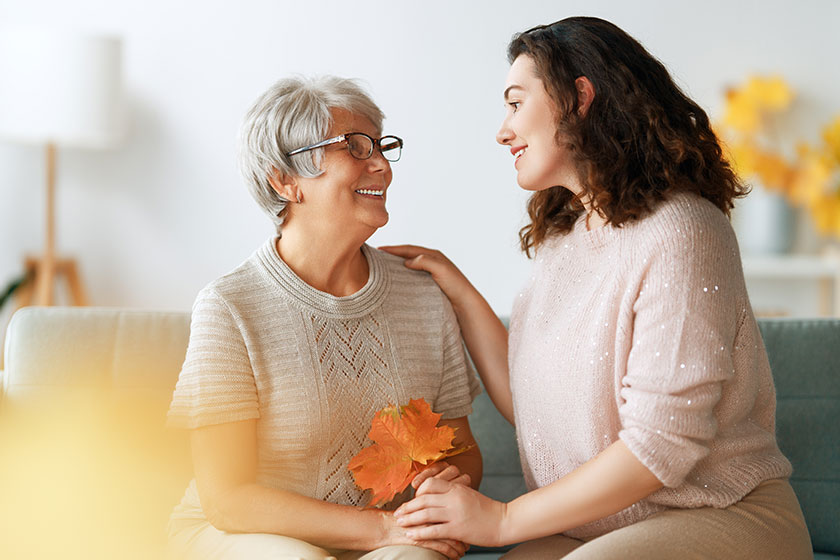 happy adult woman her senior mother autumn leaves indoors