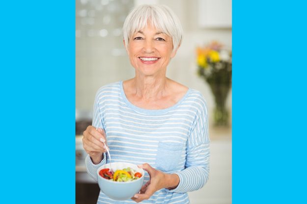 happy senior woman holding bowl of vegetable salad happy senior woman holding bowl of vegetable salad