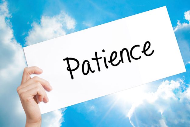 patience sign on white paper man hand holding paper with text