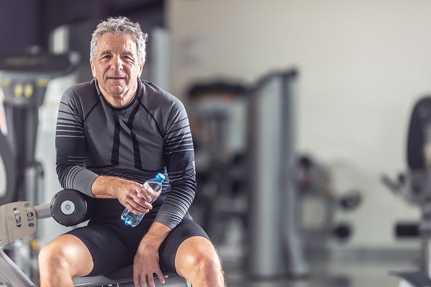 pensioner keeps himself fit working out gym resting bottle water