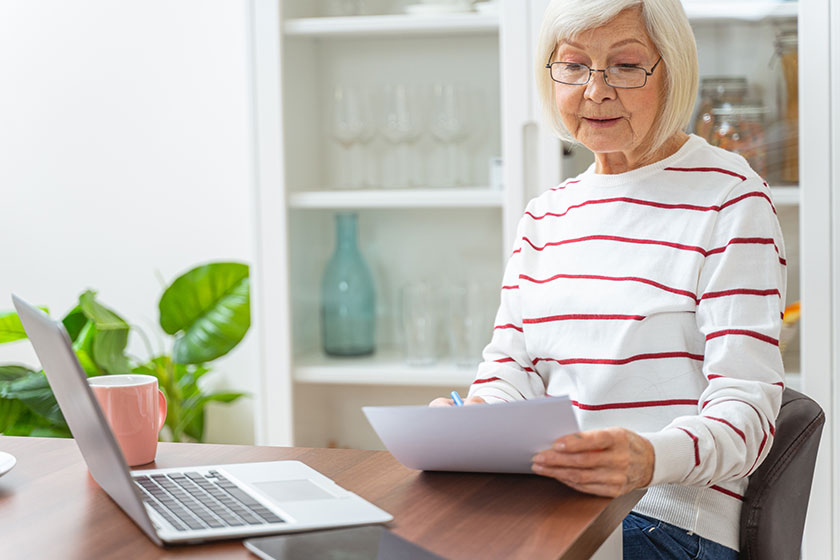 serious elderly lady sitting at the laptop