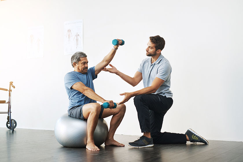 slow easy movements young male physiotherapist helping mature male patient