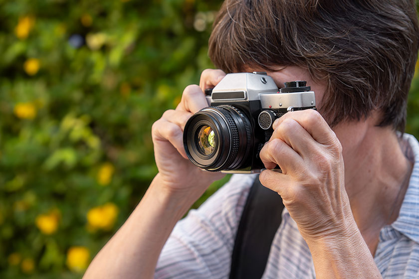 woman journalist photographer takes pictures using retro film camera outdoors woman journalist photographer takes pictures using retro film camera outdoors