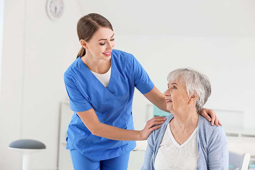 female doctor with senior woman suffering from parkinson syndrome in clinic