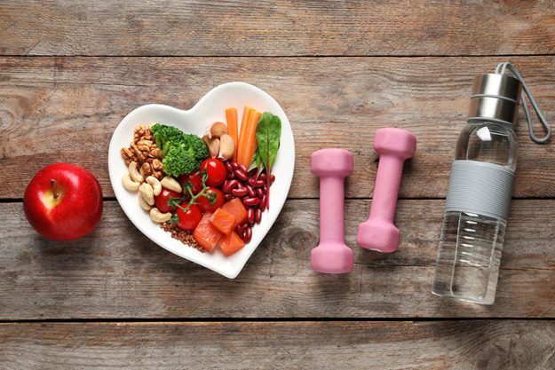 flat lay composition with plate of products for heart healthy diet on wooden background