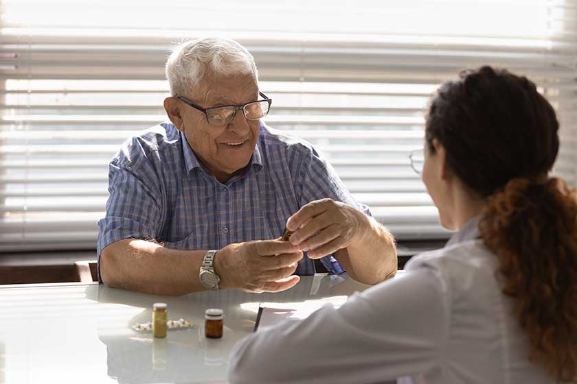 happy elder 80s male patient visiting gp doctor taking treatment