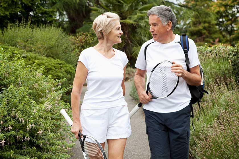 mature tennisplayers walking talking