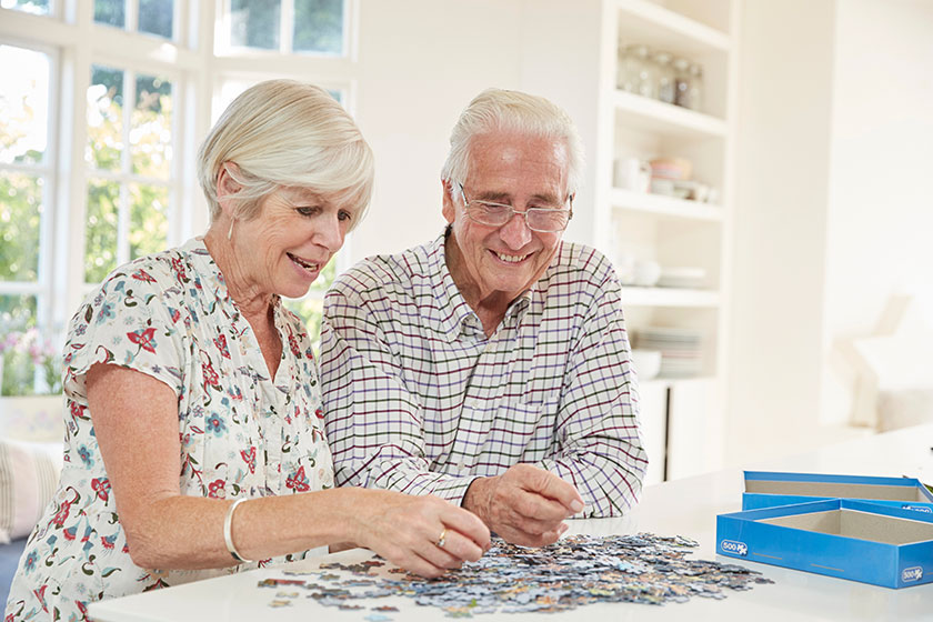 senior couple doing jigsaw puzzle home