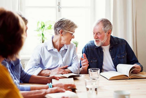 senior people in bible reading group in community center club