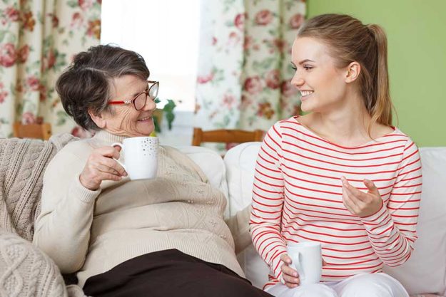 senior woman and granddaughter drinking tea senior woman and granddaughter drinking tea