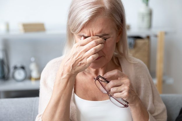 aged woman taking off glasses rubbing eyelid suffers from eyestrain aged woman taking off glasses rubbing eyelid suffers from eyestrain