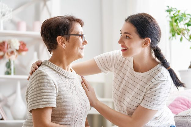 beautiful mother daughter hugging talking smiling while sitting couch home beautiful mother daughter hugging talking smiling while sitting couch home