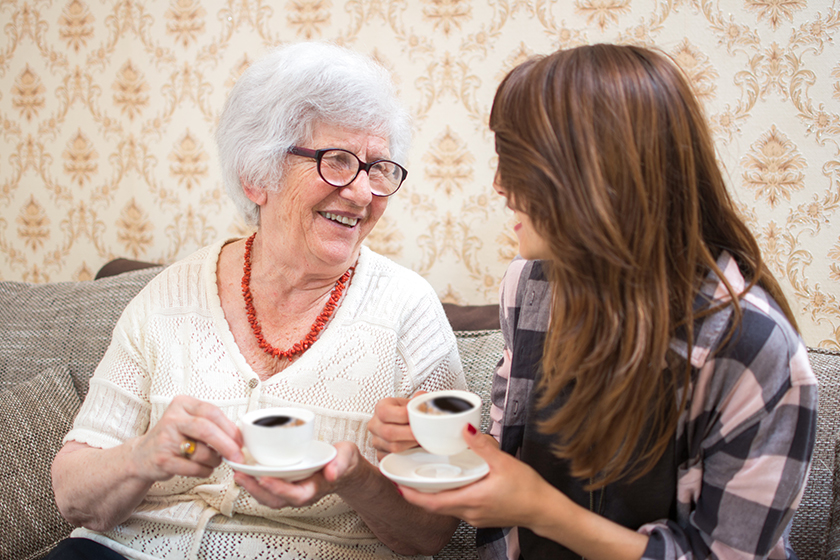 cheerful grandmother granddaughter coffee cups talking home cheerful grandmother granddaughter coffee cups talking home