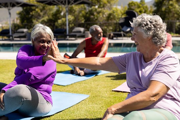 happy diverse senior friends practicing yoga high fiving sunny garden happy diverse senior friends practicing yoga high fiving sunny garden