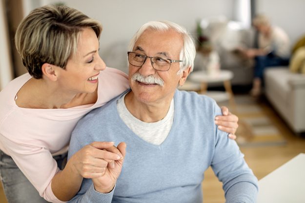 happy woman her senior father holding hands while communicating home happy woman her senior father holding hands while communicating home