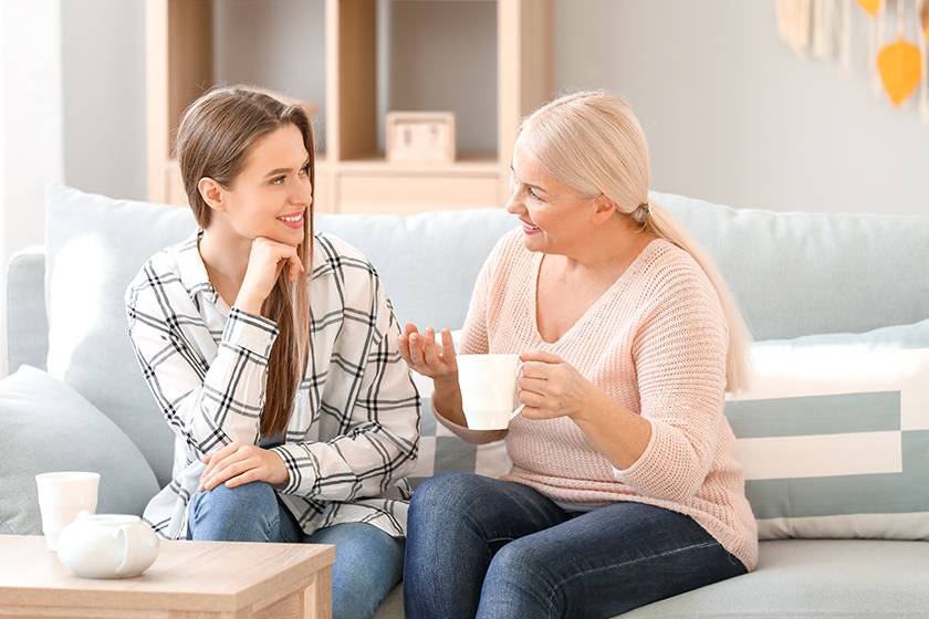 mature woman and her adult daughter spending time together at home