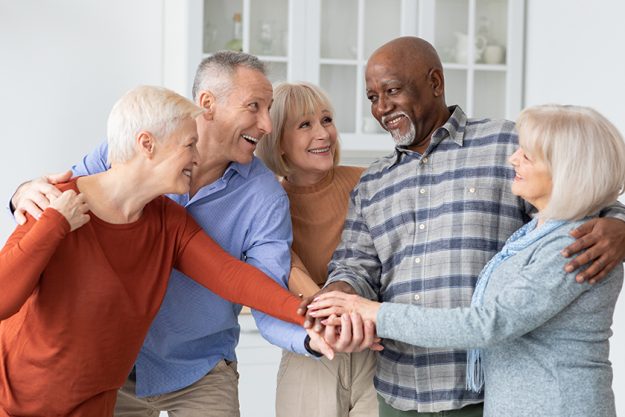 multiracial group of senior people friends holding hands together multiracial group of senior people friends holding hands together