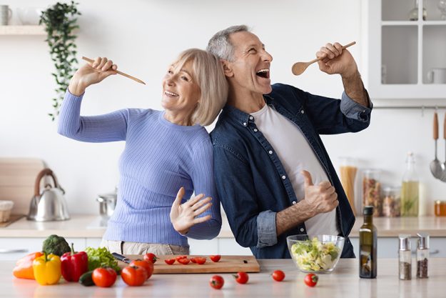 senior husband wife having fun while cooking kitchen positive elderly