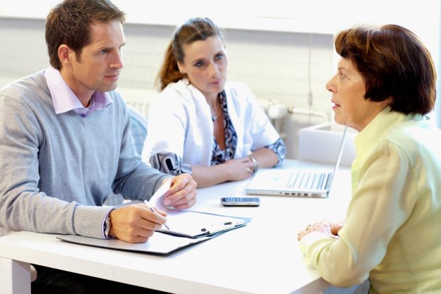 A,Resident,Talking,To,Care,Assistants,In,A,Retirement,Home A,Resident,Talking,To,Care,Assistants,In,A,Retirement,Home