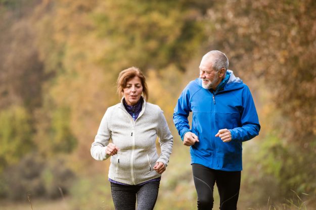Beautiful,Senior,Couple,Running,Outside,In,Sunny,Autumn,Forest