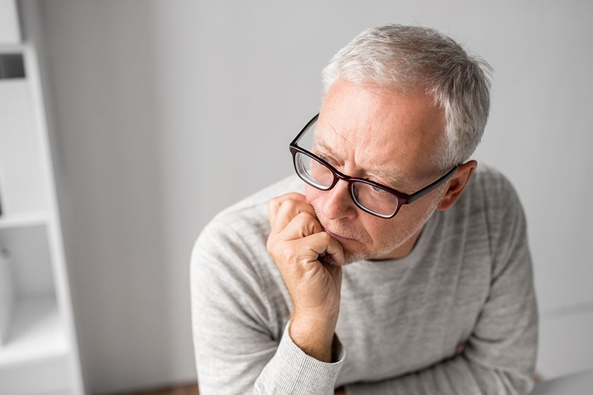 close up of senior man in glasses thinking