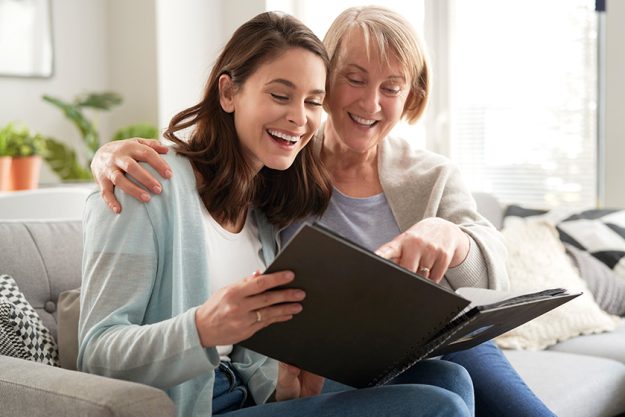 happy mother adult daughter looking photo album happy mother adult daughter looking photo album