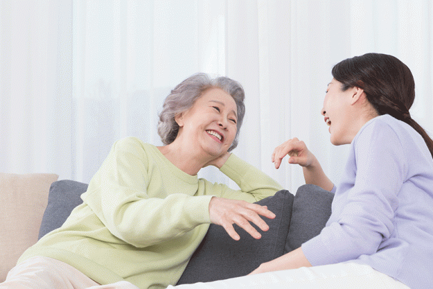happy smiling asian old mother middle aged daughter sofa