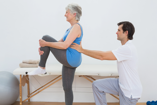 male physiotherapist examining senior womans back male physiotherapist examining senior womans back