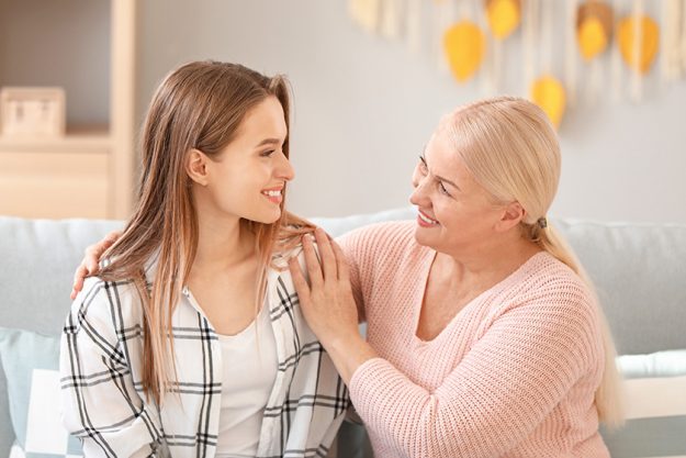 mature woman and her adult daughter spending time together at home