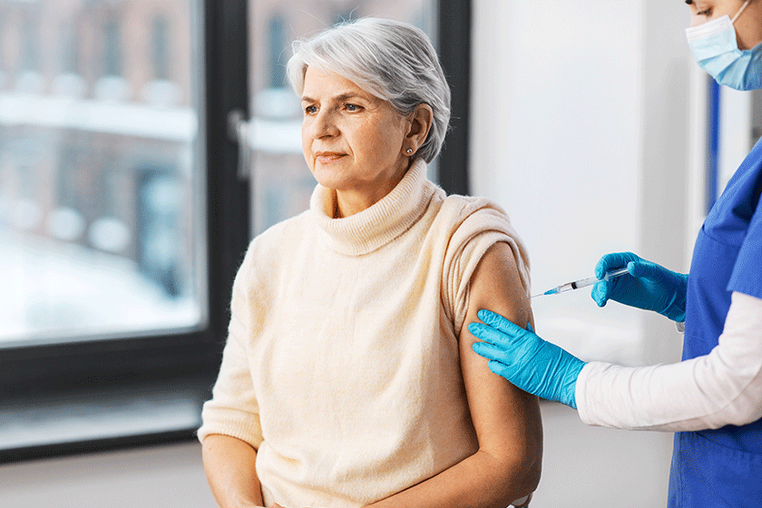 nurse with syringe making injection to woman