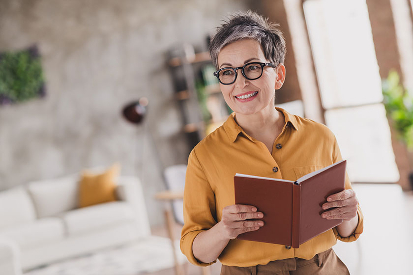 photo pretty retired woman look empty space hold book dressed