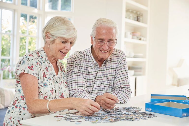 senior couple doing jigsaw puzzle home