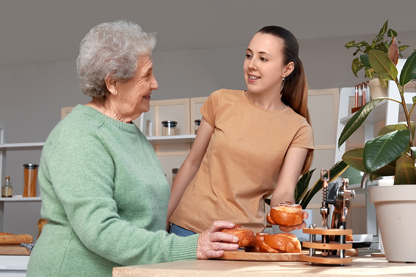 senior woman her granddaughter tasty buns kitchen