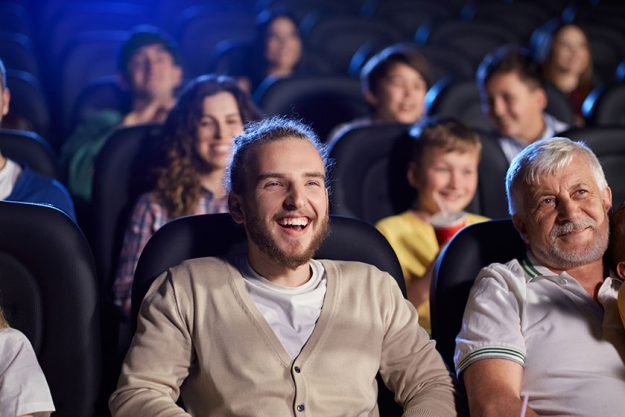 young laughing man in movie theater young laughing man in movie theater