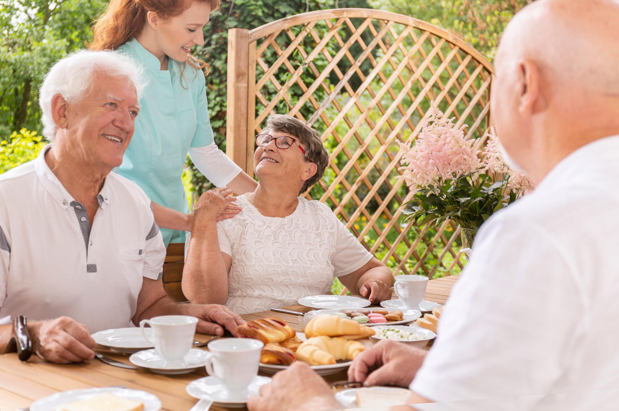 A,Tender,Caregiver,Assisting,An,Elderly,Woman,During,A,Snack