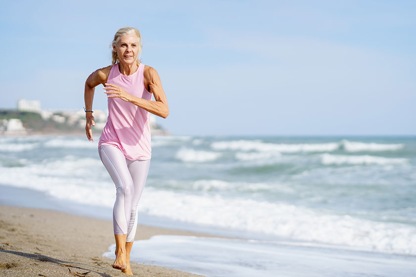 Mature woman running on beach