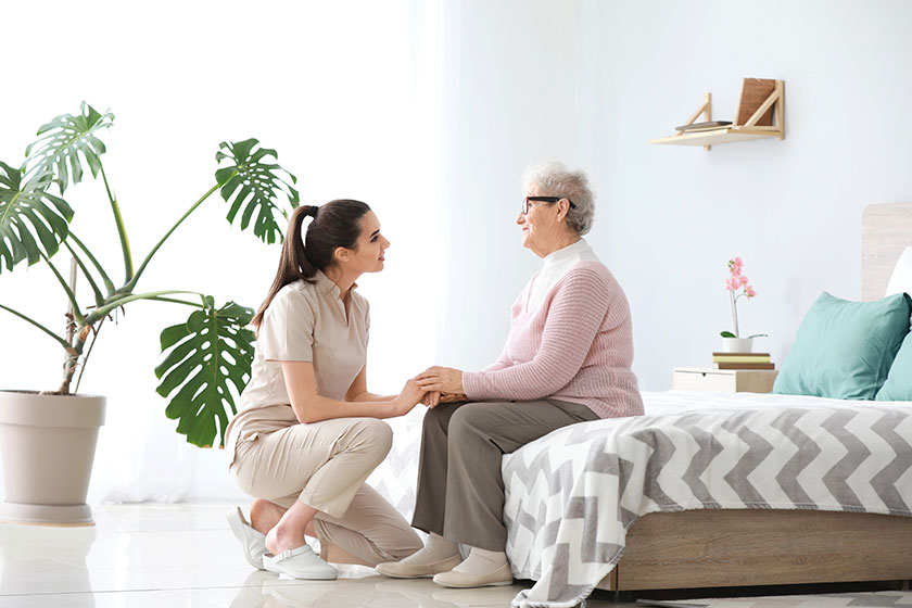 Caregiver with senior woman in nursing home