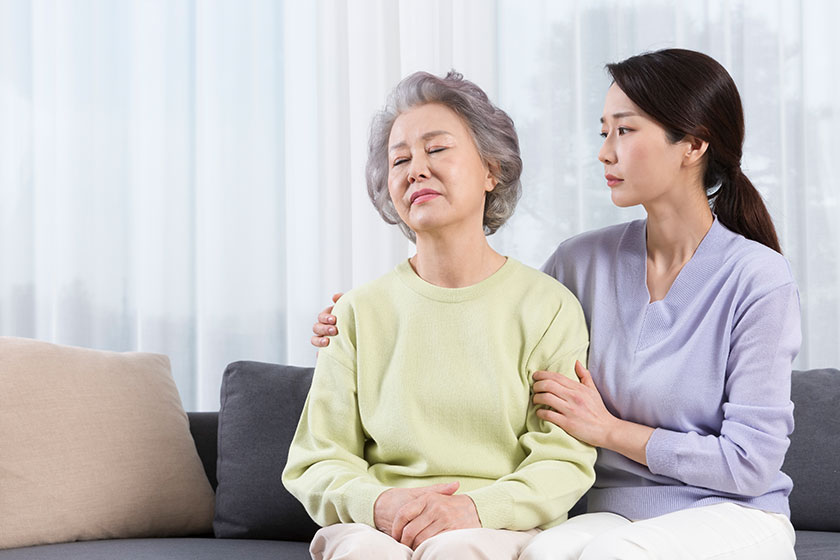 Depressed asian old mother comforted middle aged daughter