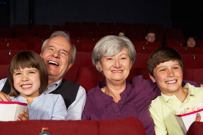 Grandparents watching film in cinema with grandchildren