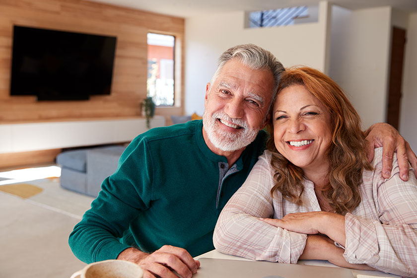 Portrait senior hispanic couple home sitting table using laptop together