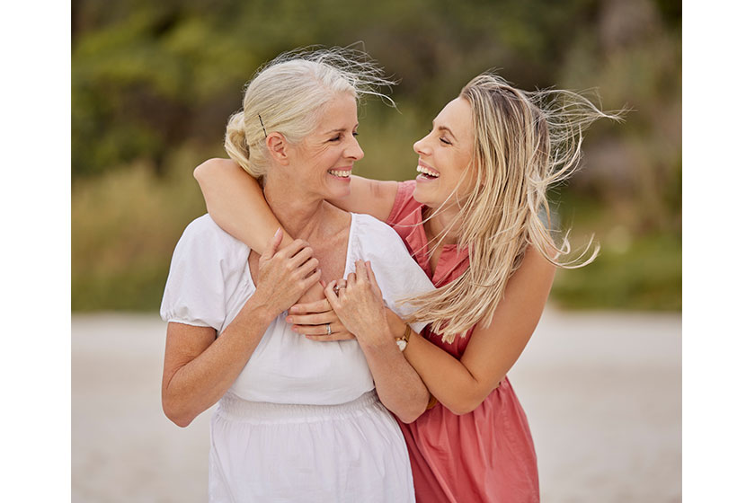 Portrait young caucasian woman spending day beach her elderly mother