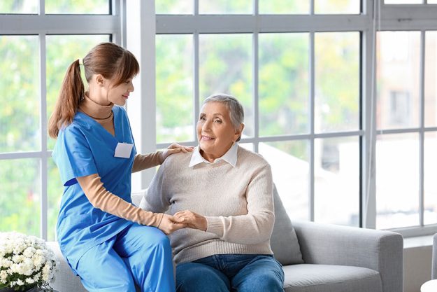 Senior woman caregiver holding hands home Senior woman caregiver holding hands home