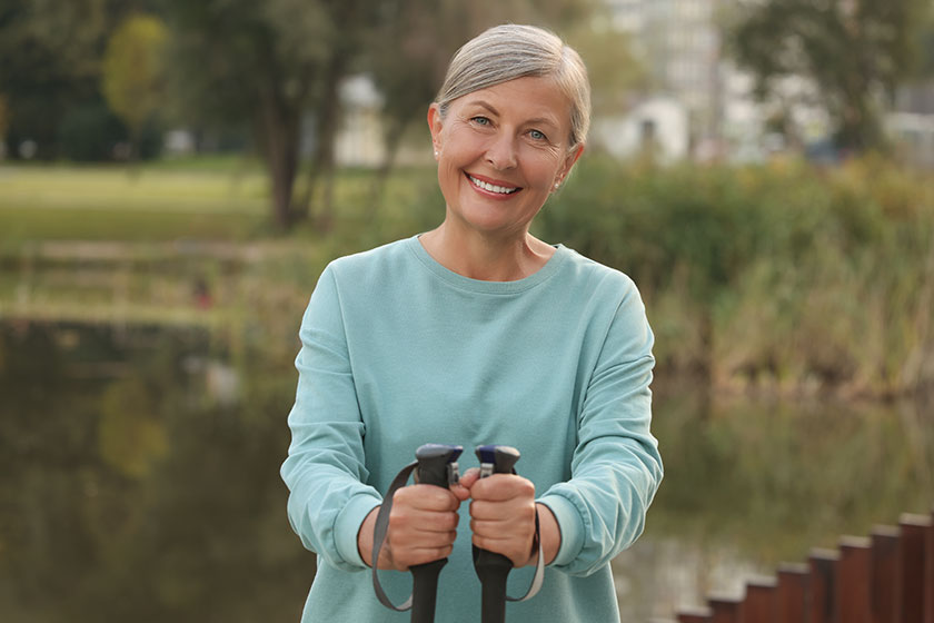 Senior woman nordic walking poles outdoors