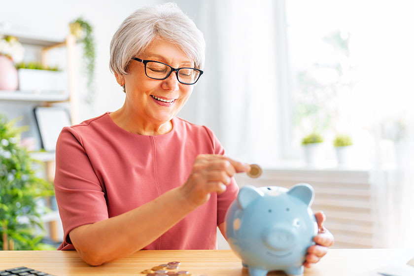 Senior woman sitting desk calculating expenses managing family budget