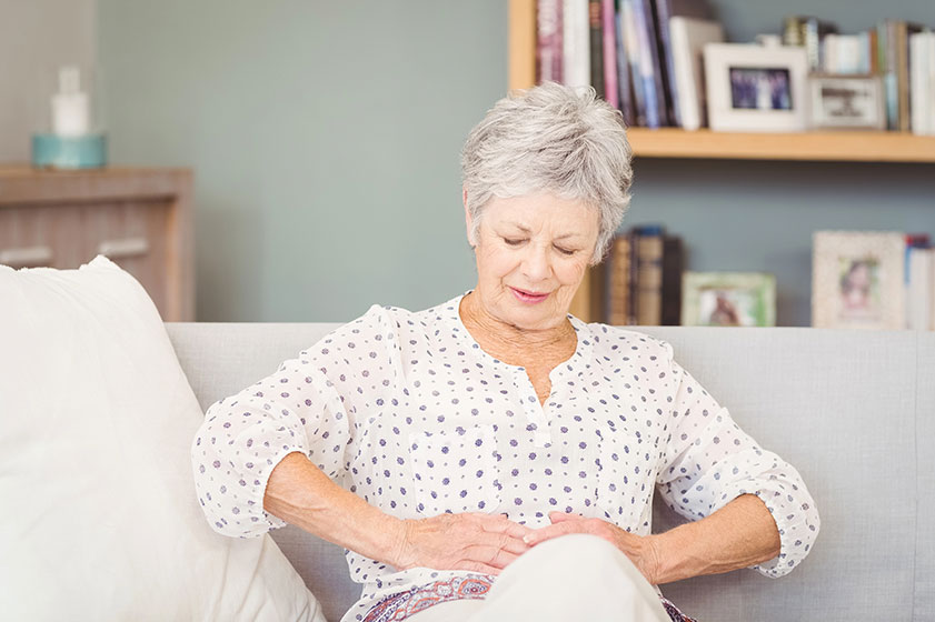 senior woman suffering from stomach pain