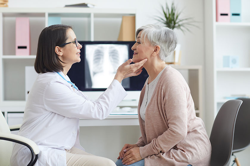 Side view portrait young female doctor examining senior woman consultation