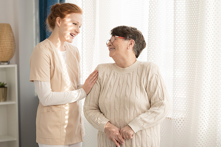 smiling nurse taking care happy elderly woman nursing home